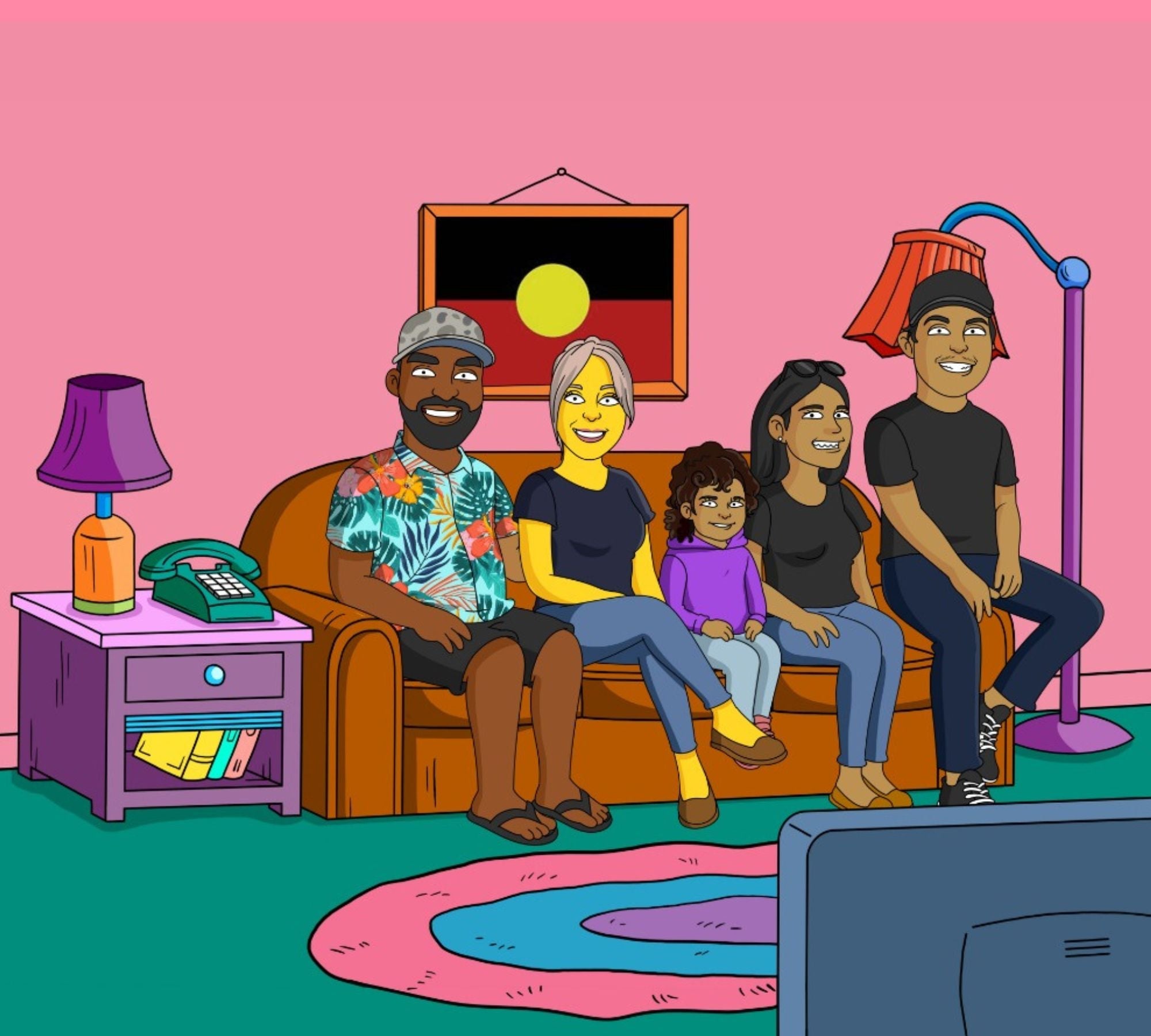 family sitting on the couch with an Aboriginal flag hanging in a frame